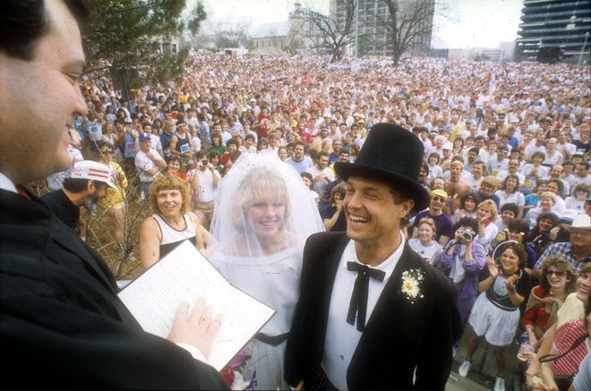Travis and Cindy Pipkin exchanging vows near the start line of the Capitol 10,000 on March 18, 1984. [Jay Godwin/American-Statesman]