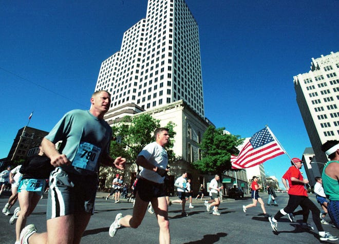 Flags and feet run up Congress Ave. during the 2003 Cap10K. [Jay Godwin/American-Statesman]